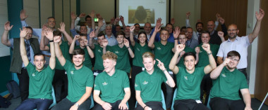 Large group of apprentice engineers in green t-shirts celebrating